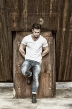 Attractive man in urban setting in front of big metal structure