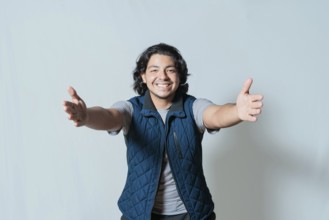 Happy young man welcoming with open arms isolated. Hospitable person opening arms to the camera