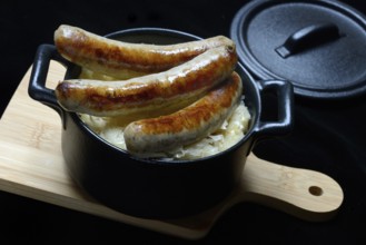 Nuremberg sausages with sauerkraut in a pot, Rostbratwurst, Germany