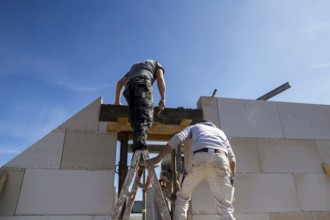 Bricklayers work on a new detached house