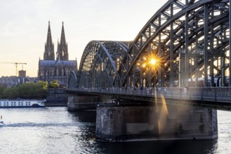Cologne Cathedral in the evening with Hohenzollern Bridge, railway bridge over the Rhine. Sunset on