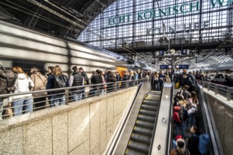 Cologne Central Station, escalators to and from the platform, passengers waiting for the train,