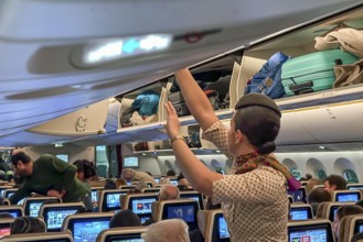 Etihad airline aircraft, interior, rows of seats with passengers. Boeing 787 aircraft on a flight