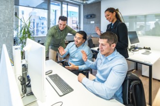 Business colleagues waving enthusiastically at the computer during an engaging video call in a