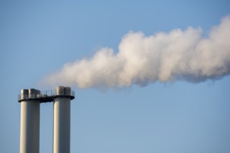 Industrial chimneys emitting smoke against blue sky, Baden-Württemberg, Germany