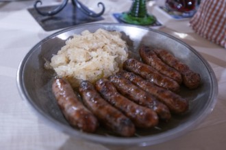 Nuremberg sausages with sauerkraut served on a pewter plate, Nuremberg, Middle Franconia, Bavaria,