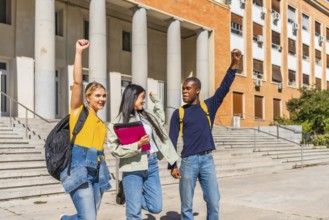 Multi-ethnic happy university students raising fist celebrating the finish the school day