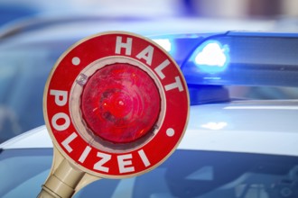(Photomontage) Symbolic image of a police check: close-up of a police trowel labelled HALT POLIZEI