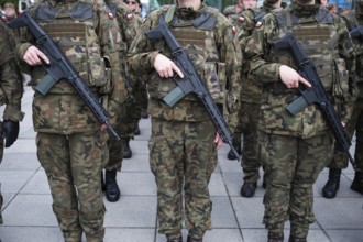Polish army soldiers holding rifles on their bellies during roll call. Poland
