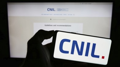 Stuttgart, Germany, 11-21-2023: Person holding mobile phone with logo of Commission Nationale de