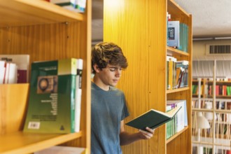 Teenager reading two bookcases