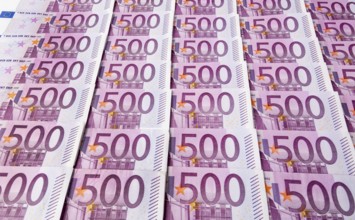 Many five hundred euro banknotes lying next to each other. Symbolic photo for wealth and investment