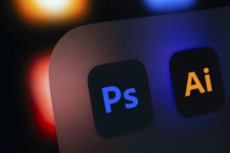 A close up of an iPad screen displaying the Adobe photoshop and adobe illustrator app
