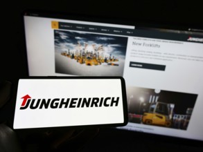 Stuttgart, Germany, 05-21-2022: Person holding smartphone with logo of German engineering company