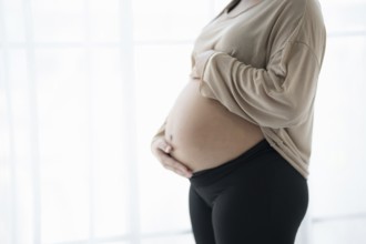 Pregnant woman holds hands on belly touching her baby caring about her health Beautiful happy