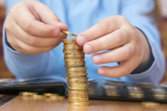 Child amassed a large pile of gold coins, close-up
