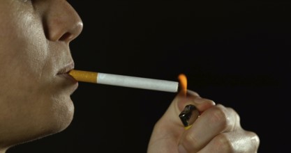 Woman smoking a Cigarette against Black Background