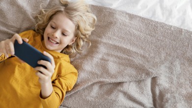 Boy bed playing mobile