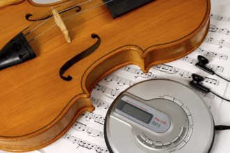 CD-player and a violin on sheet music