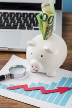 High angle office items with piggy bank growth chart