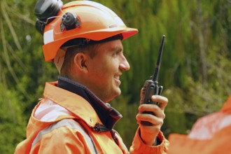 Man wearing industrial safety PPE speaking on a shortwave radio