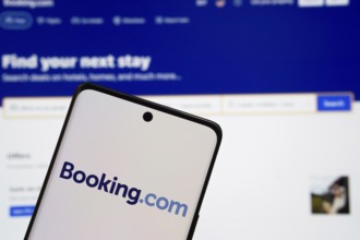 Booking.com logo is displayed on a smartphone screen, with the booking.com website visible on a