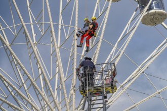 Two climbers and another worker during a rescue operation on the Ferris wheel, fire brigade