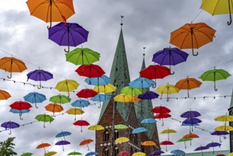 Colourful umbrellas for the HanseKulturFestival and the towers of St. Mary's Church, Hanseatic City