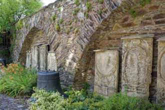 Remains of the town wall behind St Nicholas' Church with the gravestones of former priests of the