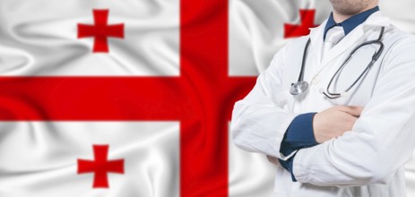 Georgia healthcare concept. Male doctor on Georgia flag. Doctor with crossed arms on Georgia flag