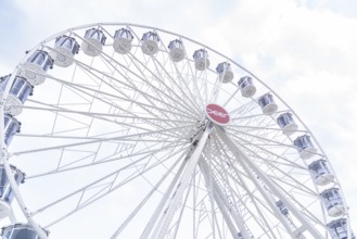 White Ferris wheel with distinctive gondolas in front of a slightly cloudy sky, Ferris wheel