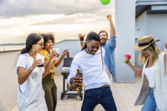 Young people enjoying a vibrant rooftop party, dancing, laughing, and sipping drinks while savoring