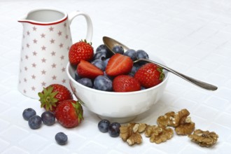 Bowl with blueberries and strawberries, walnut