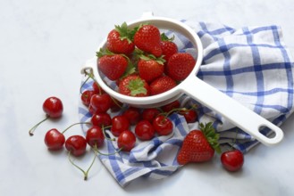 Cherries and strawberries in a colander, fruit