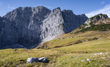 Rocky mountain ridge with summit Grubenkarspitze and Dreizinkenspitze, in front of it alpine huts