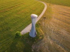 Modern building on a field with a curved path in the evening light