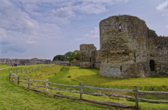 Wall and moat of Pevensey Castle, a Norman castle, in the village of Pevensey, Sussex, England,
