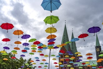 Colourful umbrellas for the HanseKulturFestival and the towers of St. Mary's Church, Hanseatic City