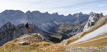 Mountaineers in front of a picturesque mountain landscape in autumn, view of the rocky ridge of the