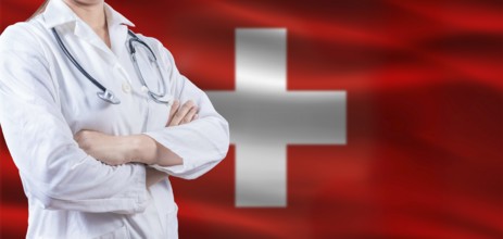 Doctor with crossed arms on Switzerland flag. Switzerland health and care concept. Female doctor on