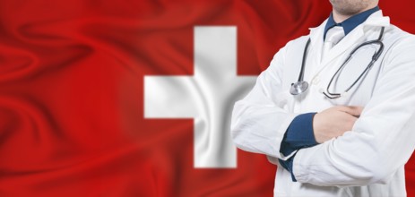 Switzerland healthcare concept. Male doctor on Switzerland flag. Doctor with crossed arms on