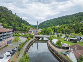 A picturesque river landscape with bridge and surrounding buildings, Ferris wheel construction for