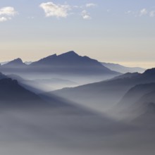 Mountain silhouettes... Alpine peaks and mountain ranges in the Bavarian Alps, light fog rises from