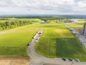 New industrial area ING Park and a rural road under a cloudy sky, Nagold, district of Calw, Germany