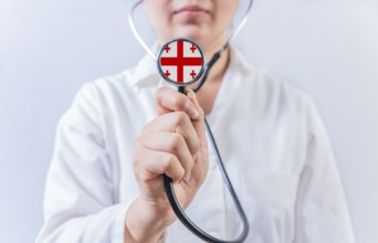 Female doctor holding stethoscope with Georgia flag. National health system of Georgia
