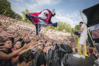 Eisbären Berlin players throw scarves and other fan merchandise into the audience at the Berliner