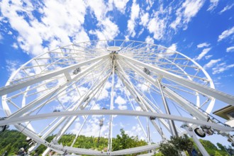 View from below of a partially erected Ferris wheel with a blue, cloudy sky, Ferris wheel