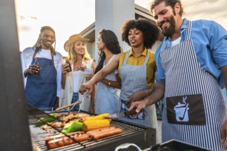 Chefs cooking meat and vegetables on barbecue grill during rooftop party with friends drinking beer