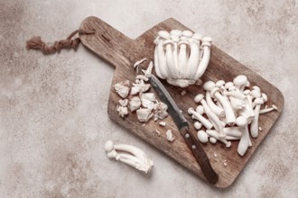 Freshly sliced Shimizhi mushrooms, on a wooden chopping board, ready to cook, close-up, no people