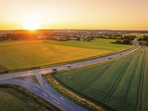 View of cars on a road next to fields at sunset, wide and peaceful scene, Renningen, Germany